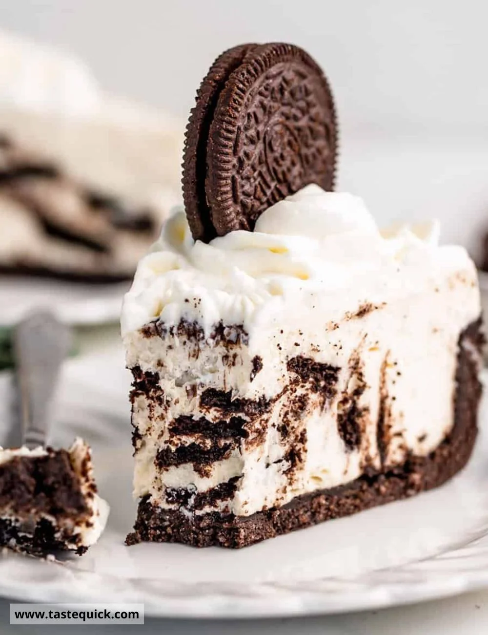 No Bake Oreo Cheesecake topped with crushed Oreos and chocolate drizzle