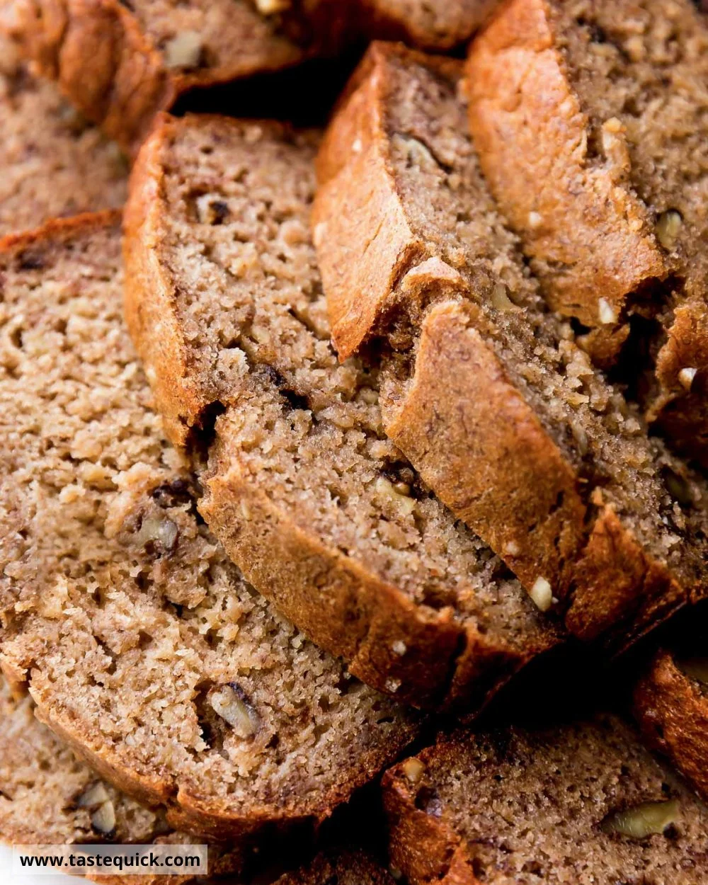 Freshly baked banana bread on a cooling rack with brown bananas