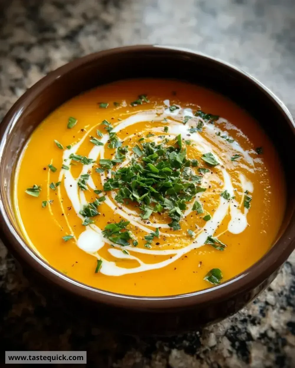 Bowl of creamy butternut squash soup garnished with herbs.