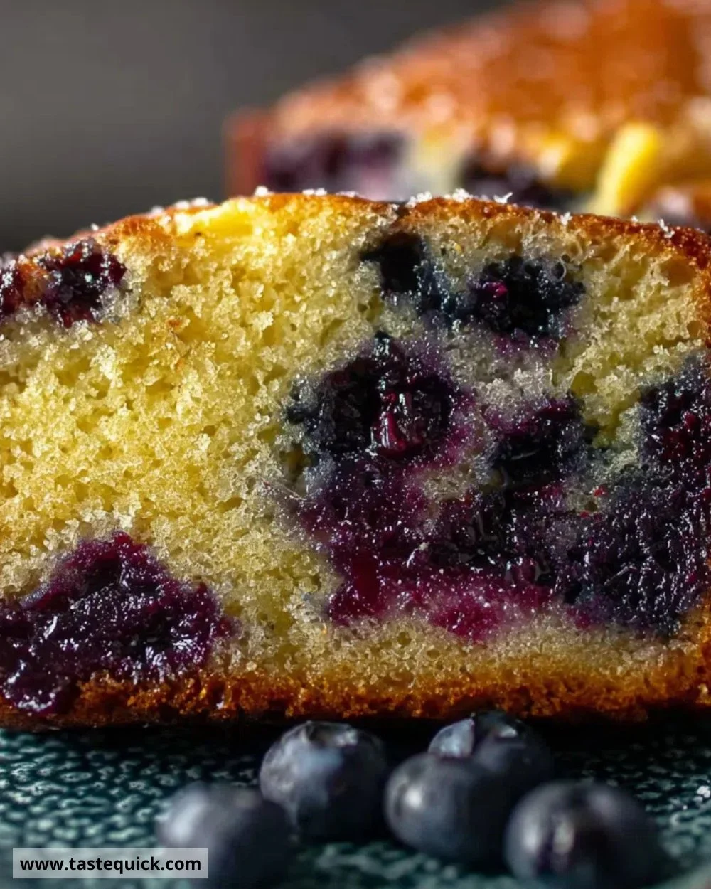 Slice of easy blueberry lemon loaf with blueberries and lemon zest