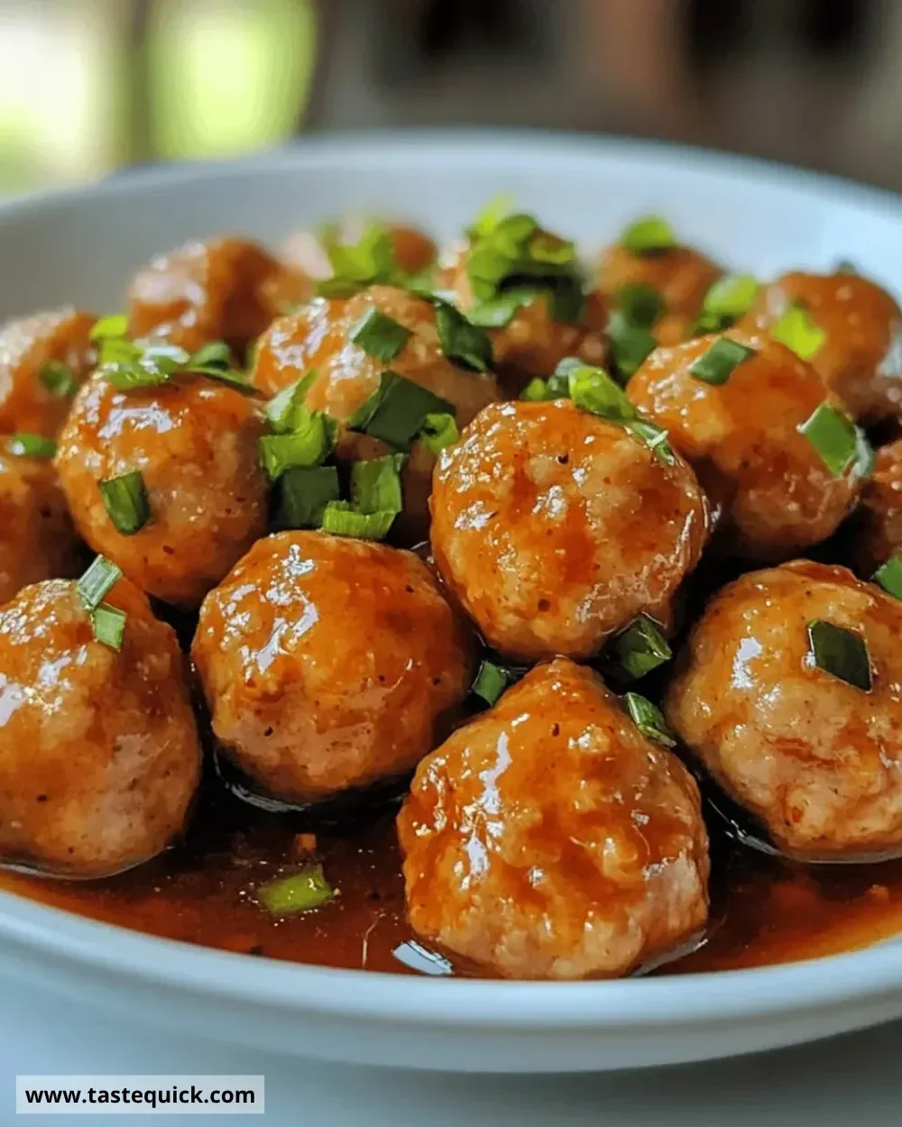 Juicy sweet chili chicken meatballs served on a plate with a dipping sauce
