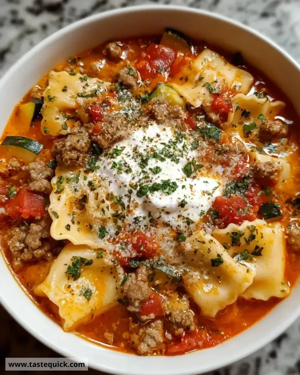 Bowl of Sausage Lasagna Soup with melted cheese and herbs on top