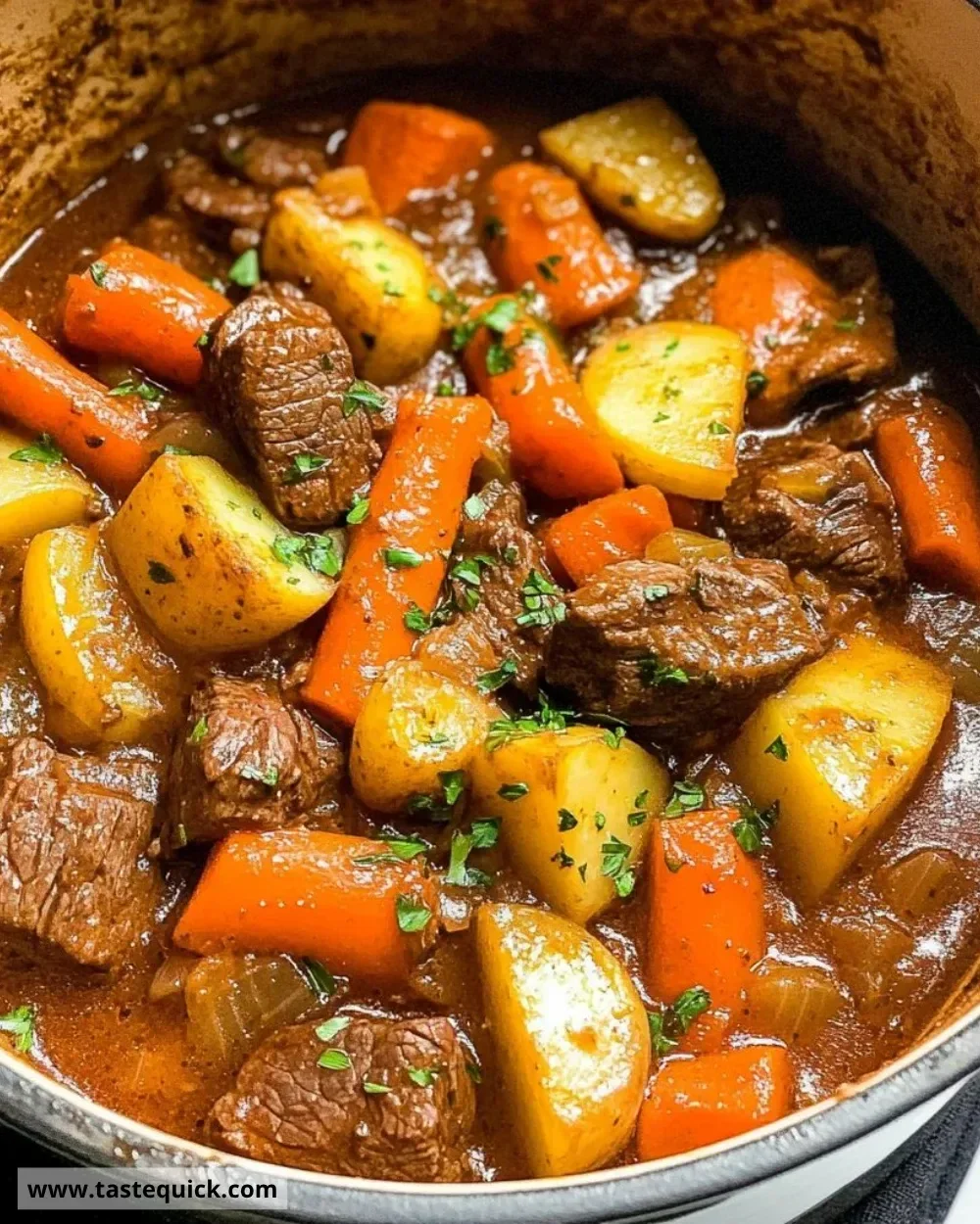 Delicious stove top beef stew simmering in a pot with vegetables and seasonings.