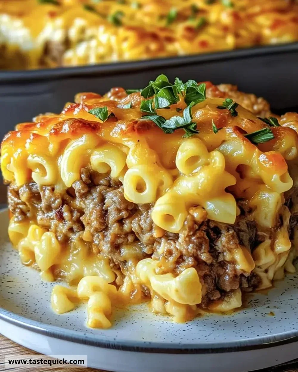 Cheesy beef macaroni bake topped with cheese and herbs in a casserole dish