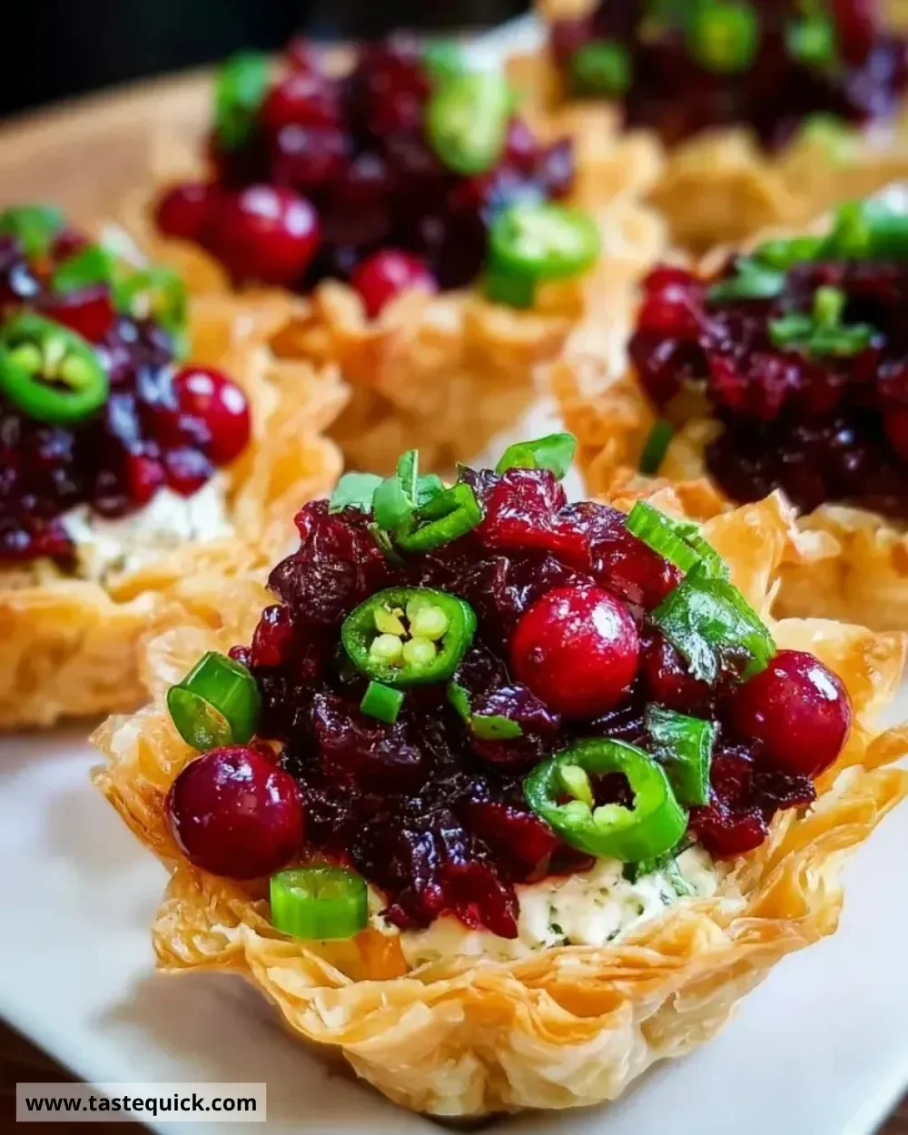Cranberry Jalapeño Dip Tarts served on a platter at a festive gathering