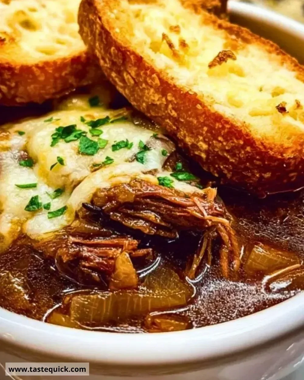 Delicious French onion beef short rib soup in a rustic bowl with herbs on top.