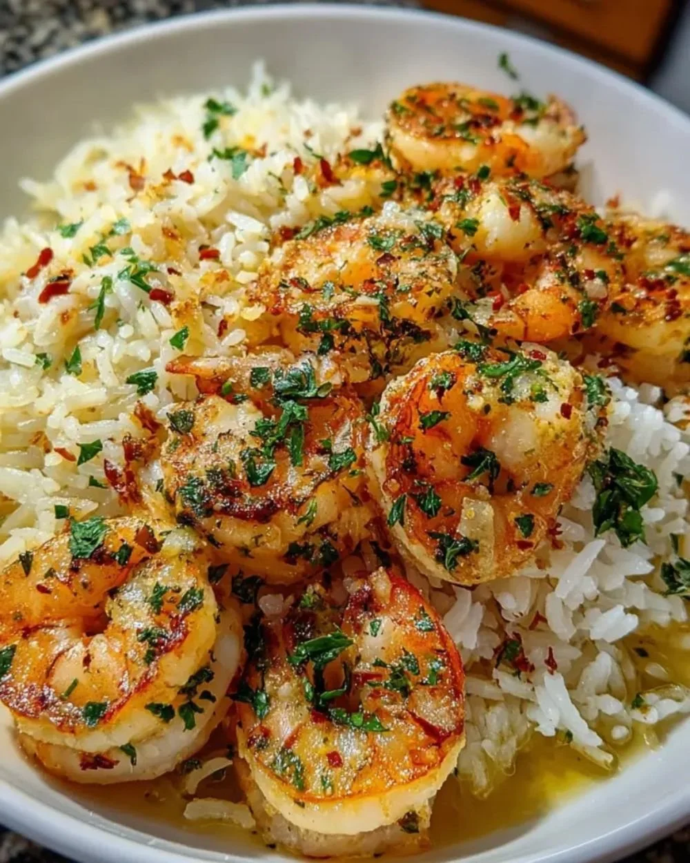Garlic Butter Shrimp Rice Bake served in a bowl with herbs on top