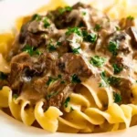 Slow cooker beef stroganoff served in a bowl with garnishes