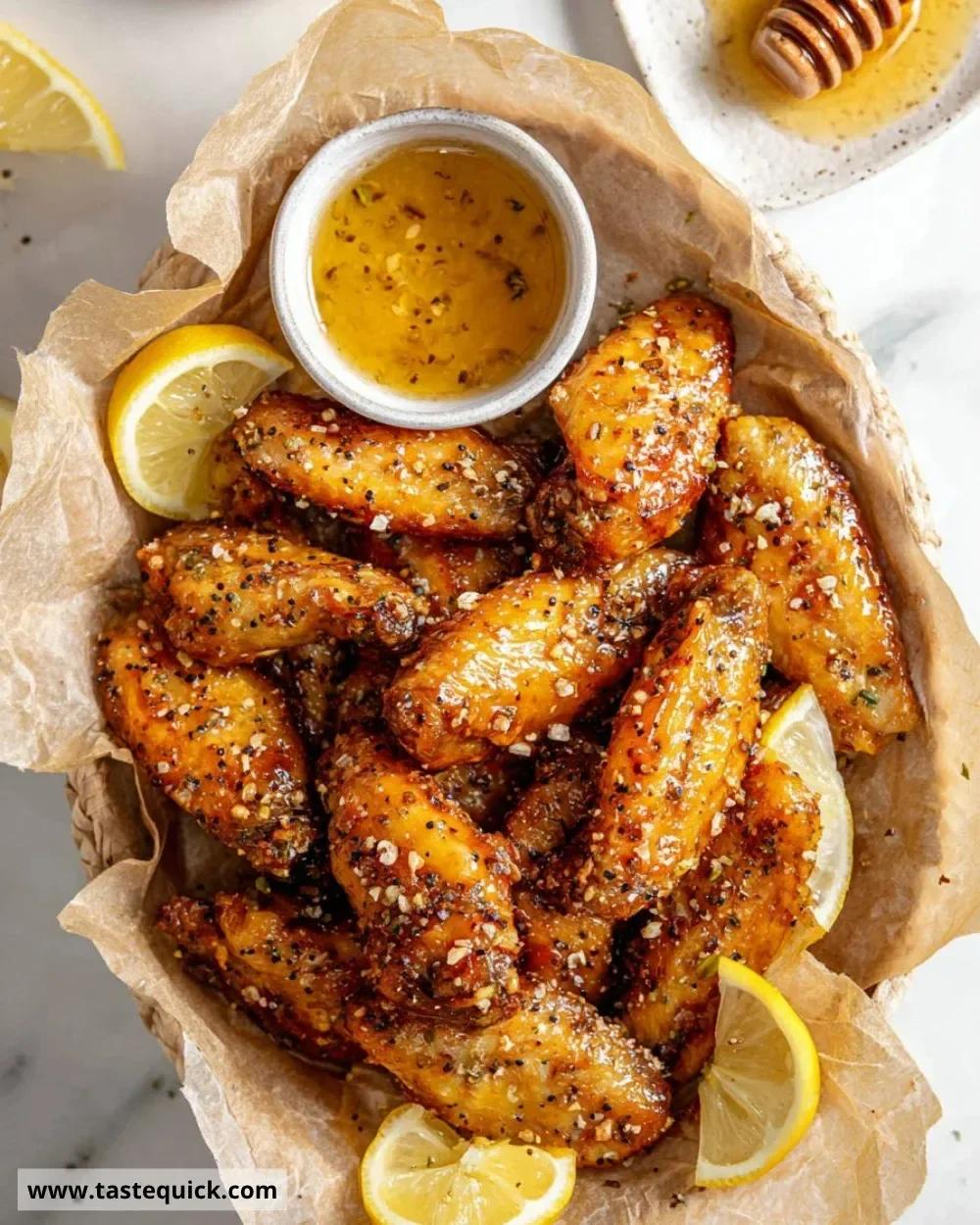 Delicious honey lemon pepper wings on a platter, garnished with herbs