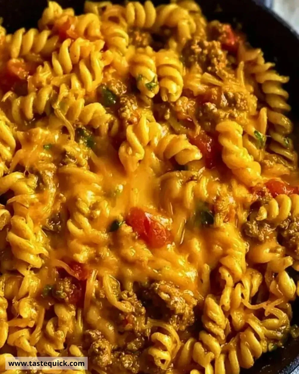 One-Pot Cheesy Taco Pasta Skillet in a large skillet with toppings.