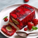A slice of Strawberry Jelly Summer Pudding with fresh strawberries on top