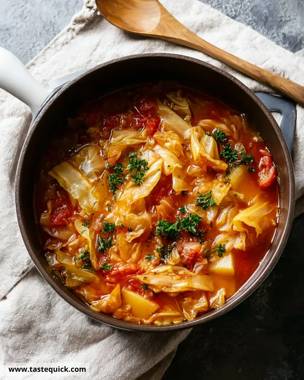 Bowl of Sweet and Sour Cabbage Soup garnished with fresh herbs.