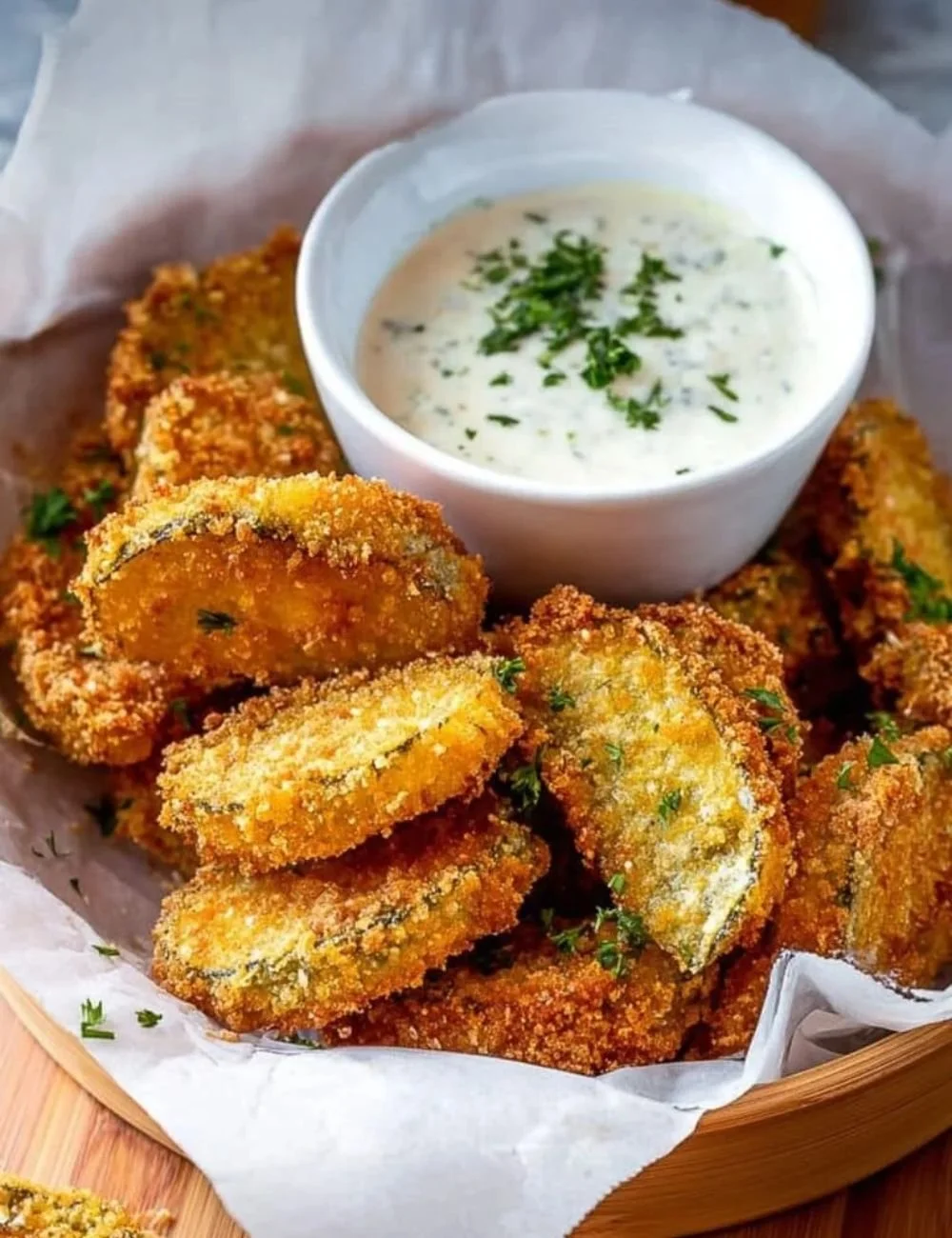 Plate of crispy fried pickles served with a dipping sauce.