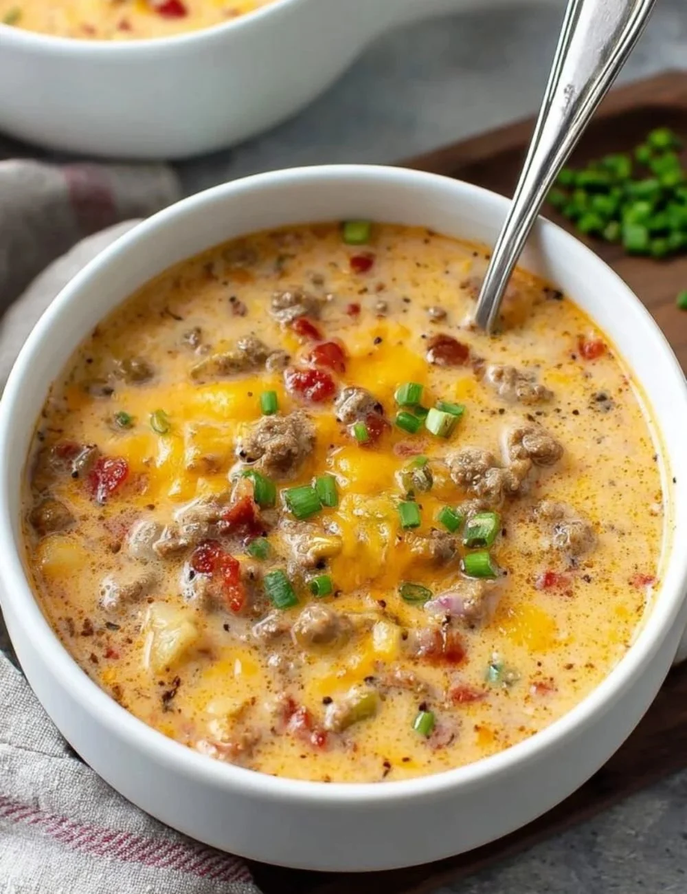 Bowl of creamy cheeseburger soup topped with cheese and herbs