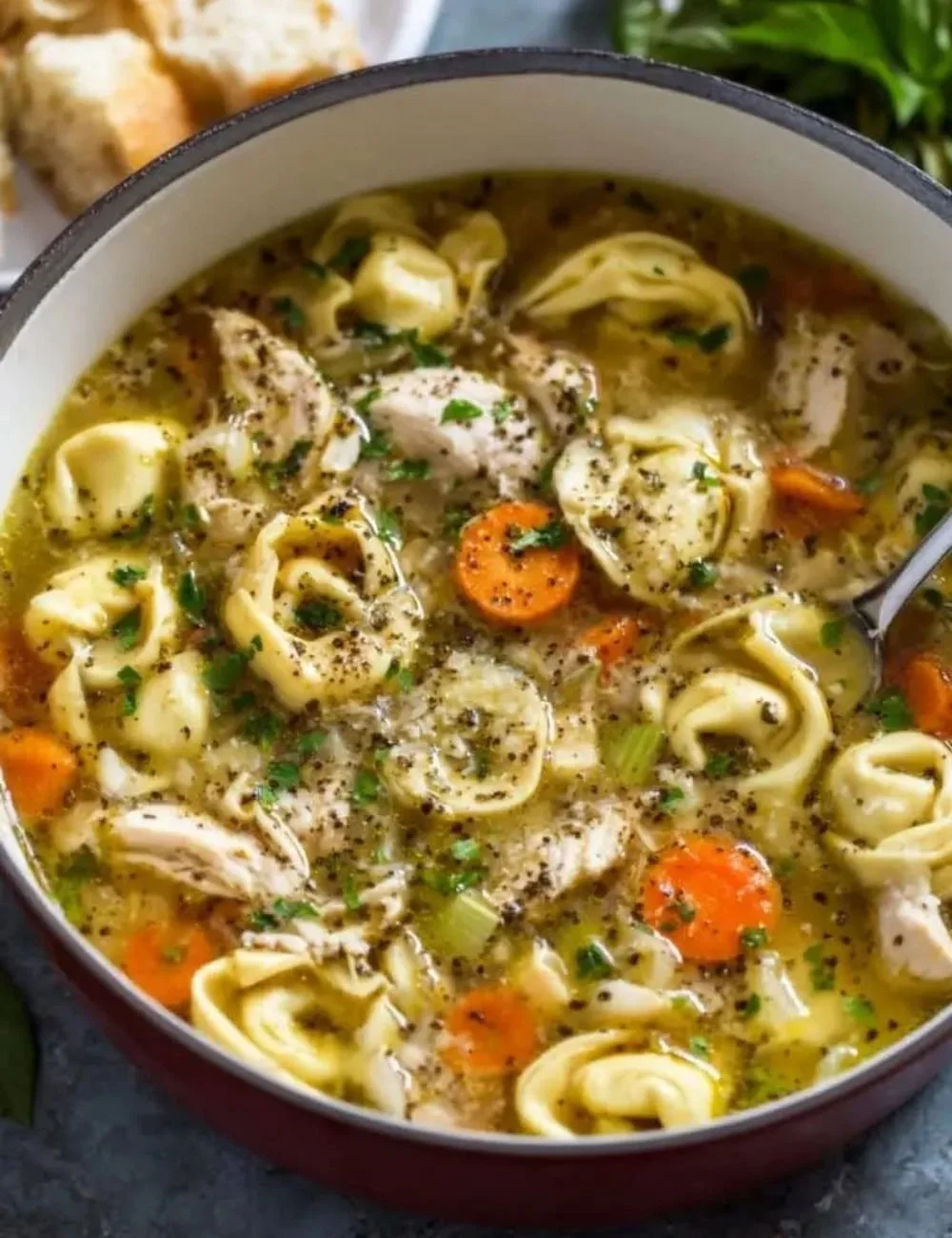 Delicious Chicken Tortellini Soup in a bowl topped with herbs
