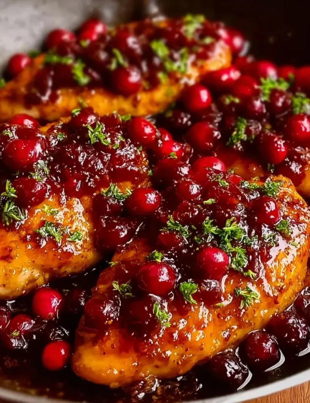 Cranberry Orange Glazed Chicken served with fresh herbs and seasonal vegetables.