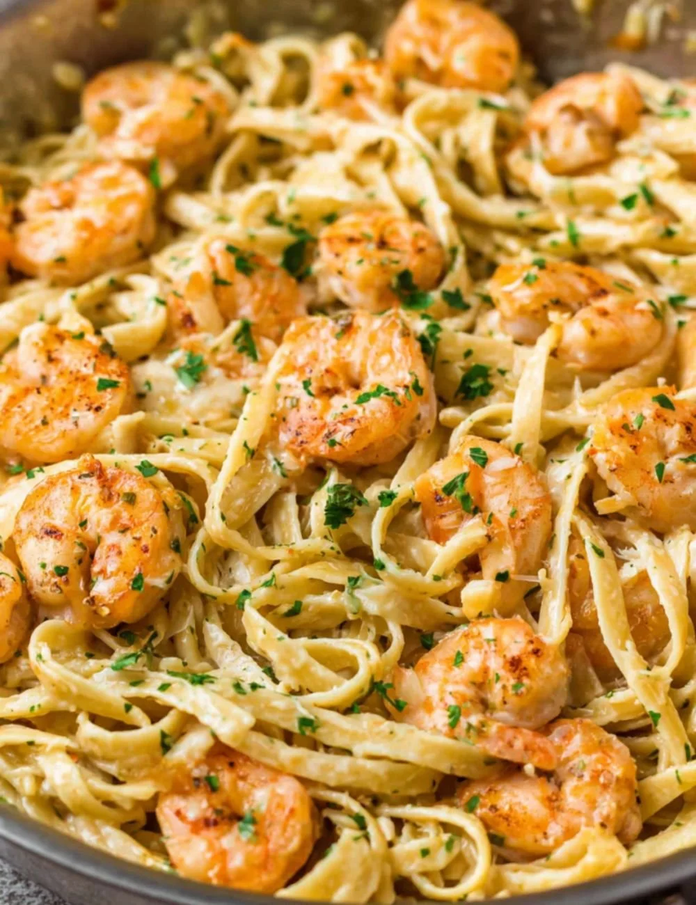 Delicious creamy garlic shrimp pasta served in a bowl with herbs and spices