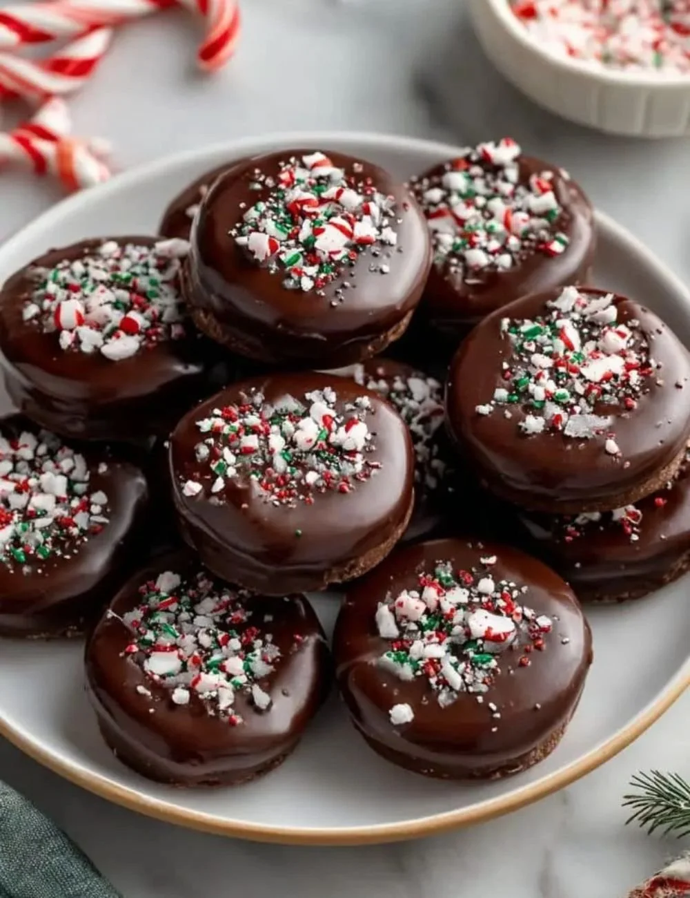 Homemade peppermint patties arranged on a plate, showcasing their minty chocolate goodness.
