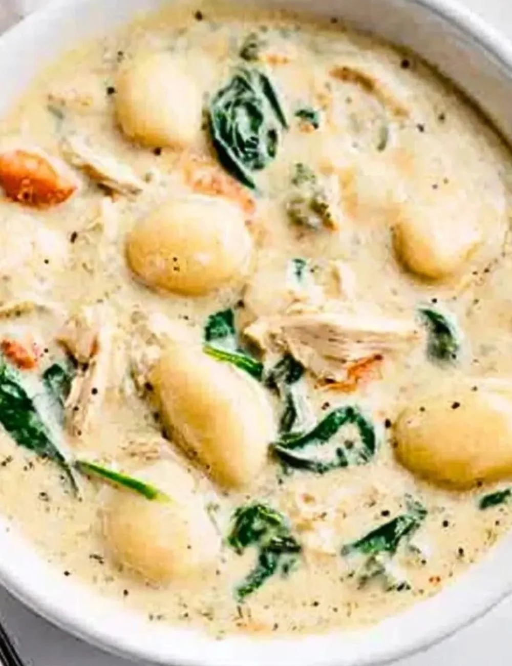 Bowl of Olive Garden chicken gnocchi soup with chicken, gnocchi, and fresh herbs