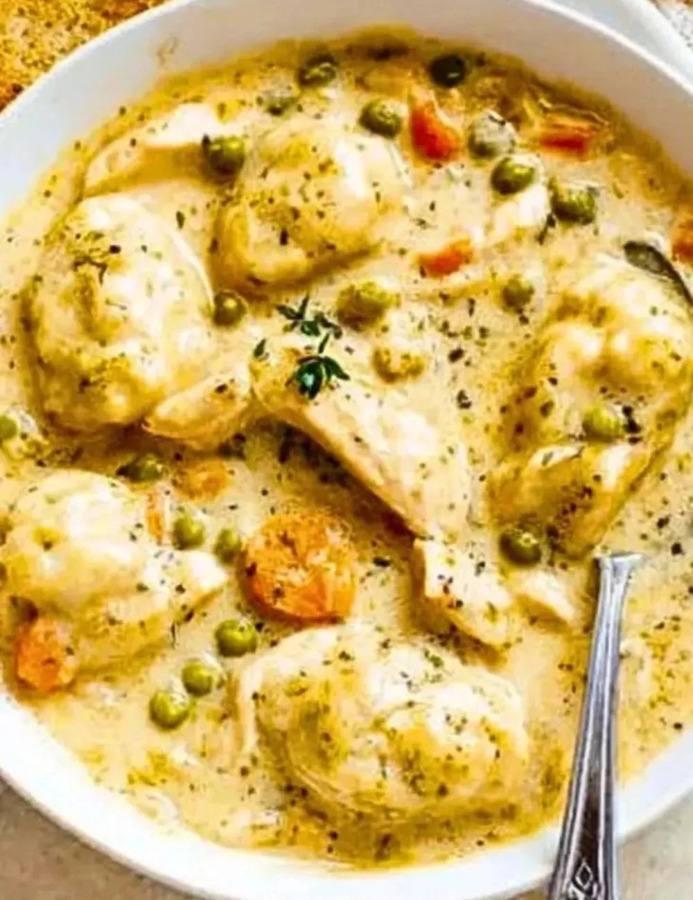 Bowl of One Pot Chicken Dumpling Soup with fresh herbs and dumplings