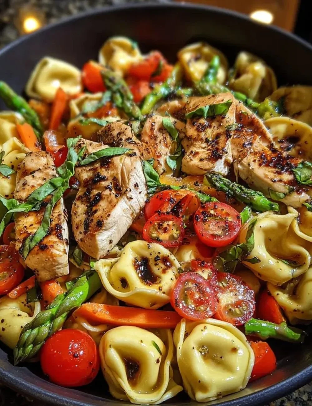 Warm balsamic chicken tortellini salad with vibrant vegetables and dressing.