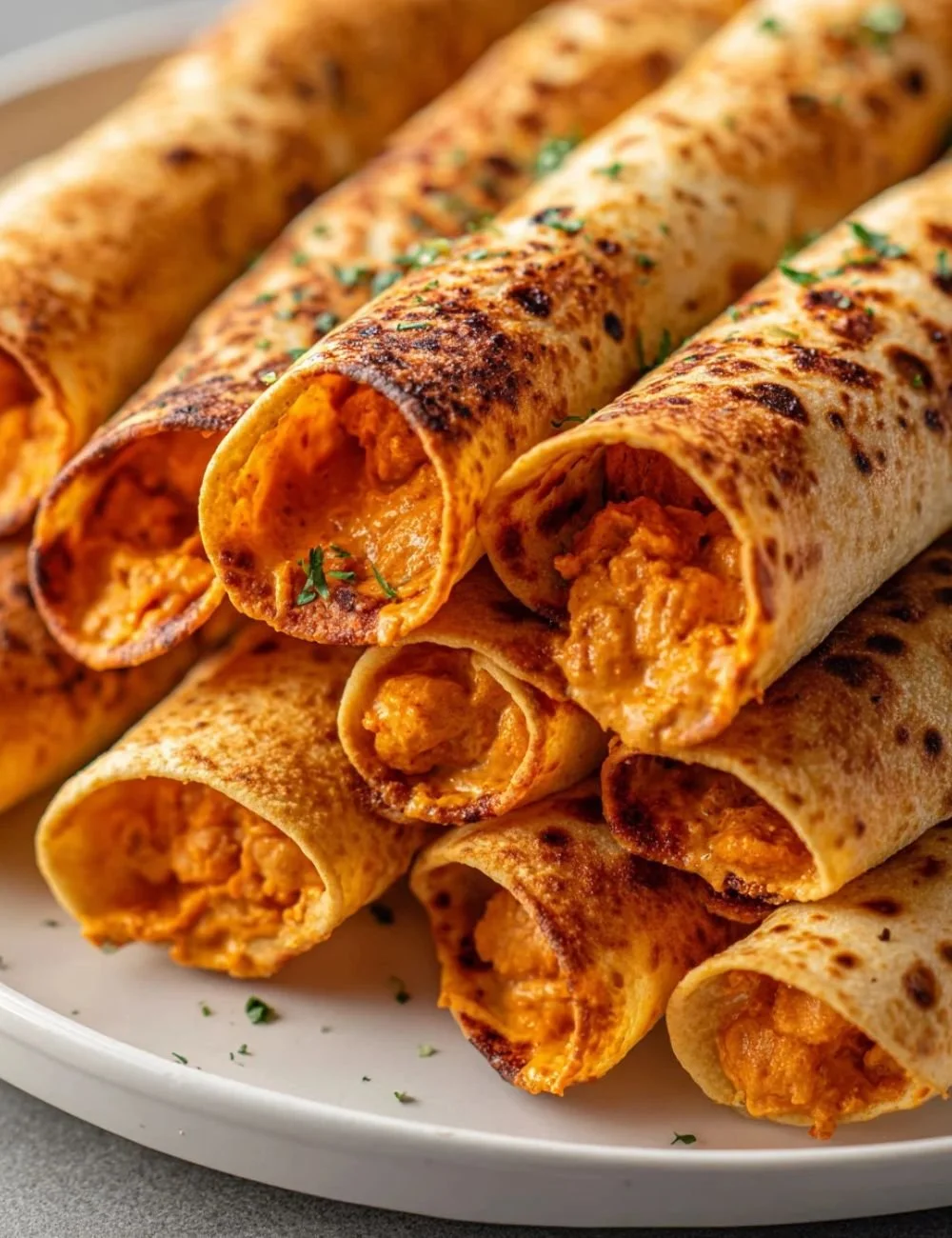 Buffalo Chickpea taquitos served on a platter, garnished with fresh herbs.