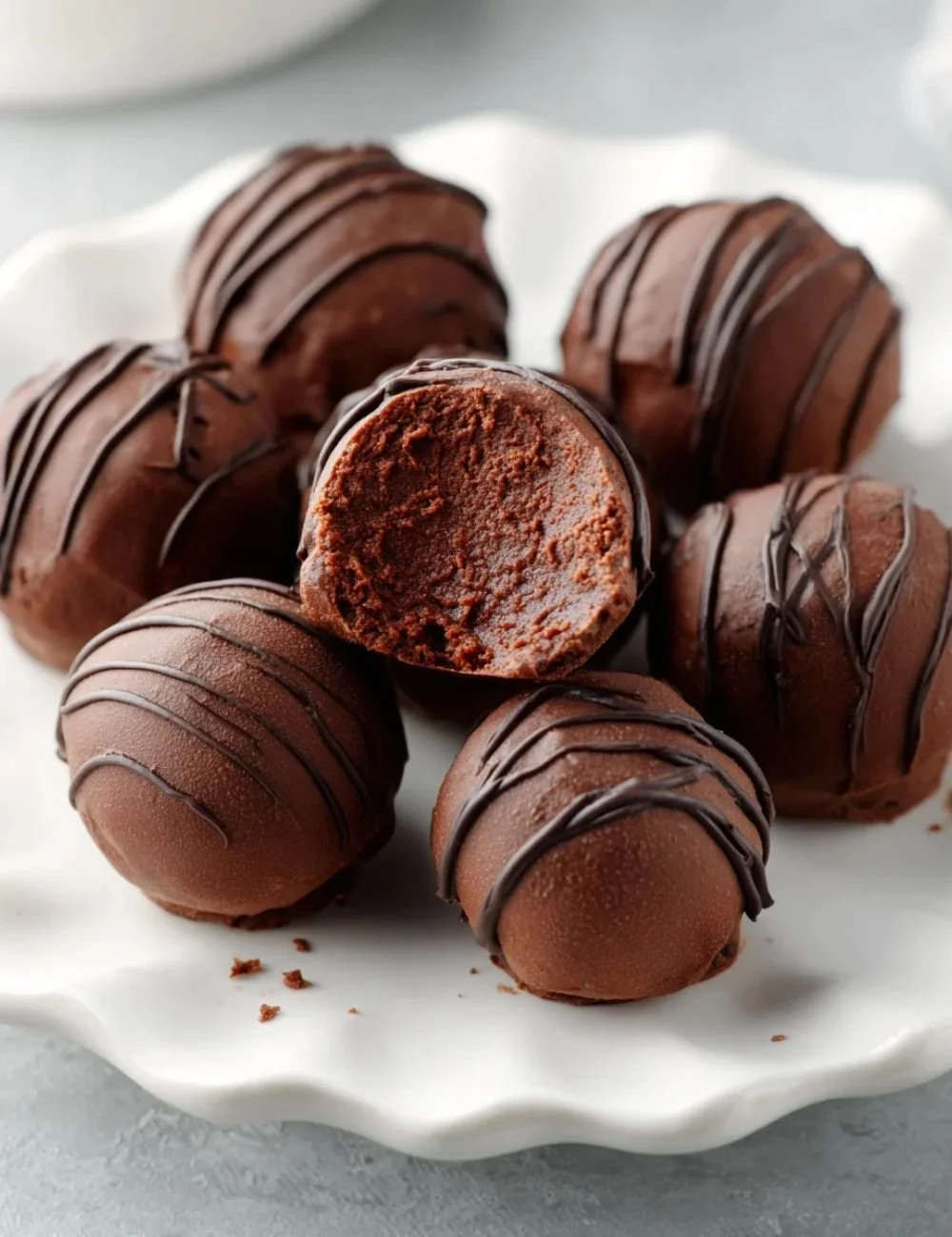 Homemade chickpea chocolate truffles topped with cocoa powder on a plate.