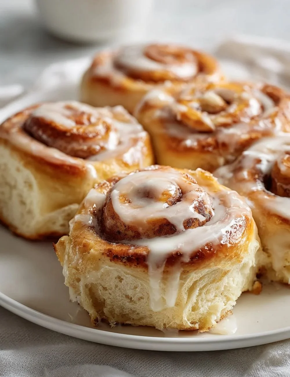 Homemade cottage cheese cinnamon rolls on a plate garnished with icing