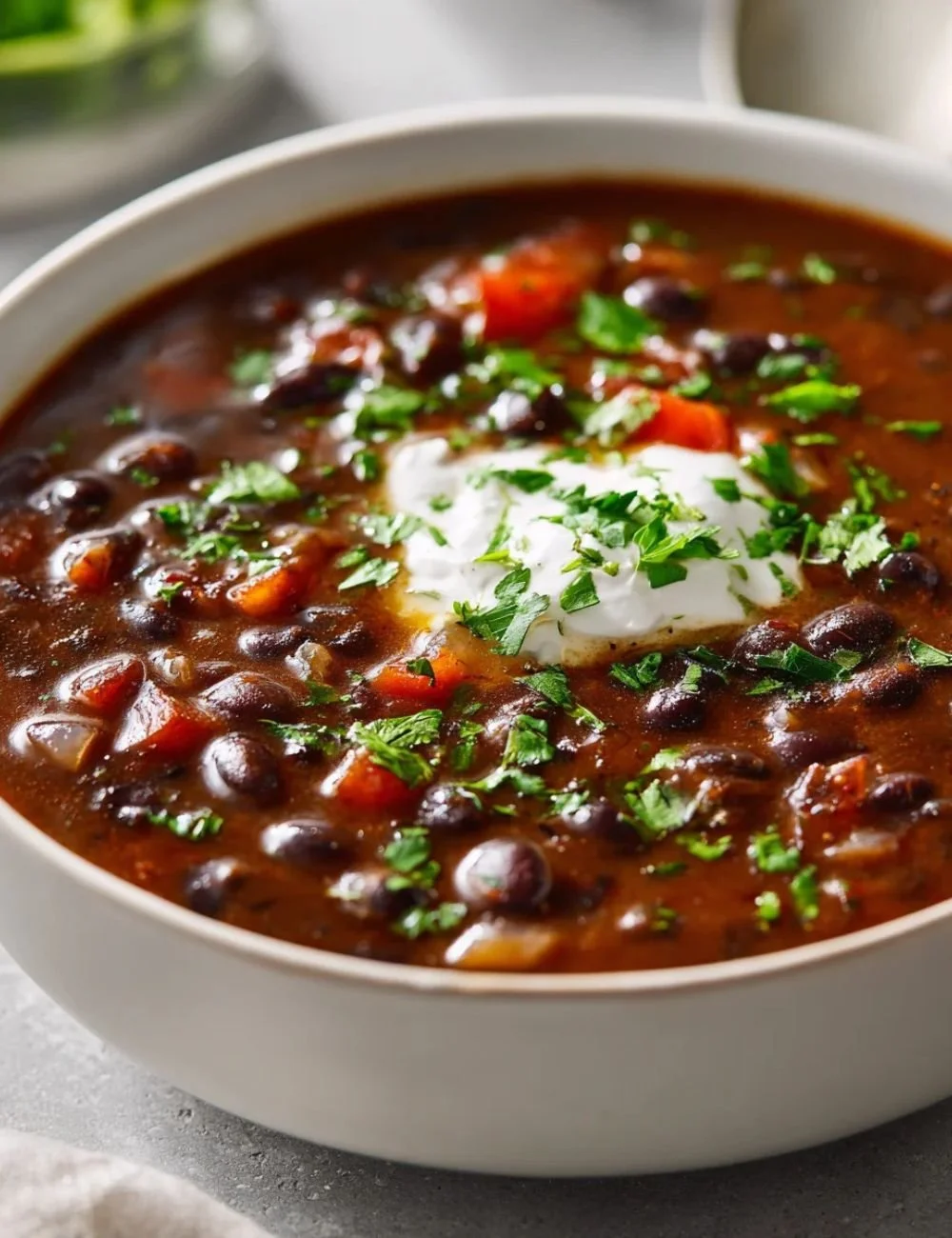 Bowl of easy black bean soup topped with cilantro and lime