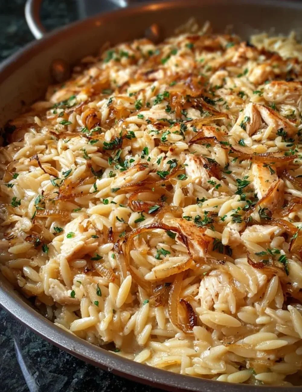 Delicious bowl of French Onion Chicken Orzo with melted cheese and herbs