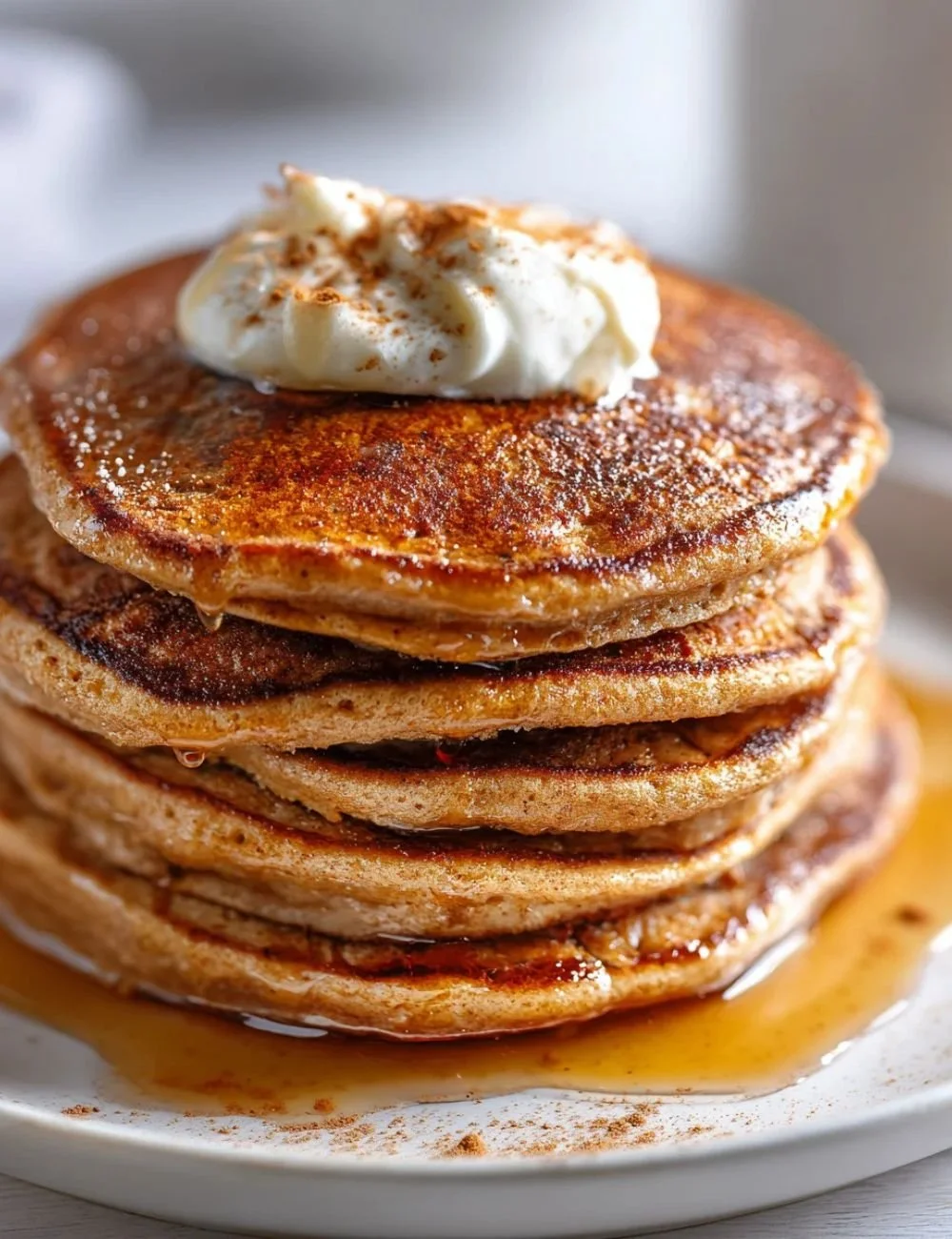 Fluffy gingerbread pancakes topped with syrup and icing, featuring gin extract.
