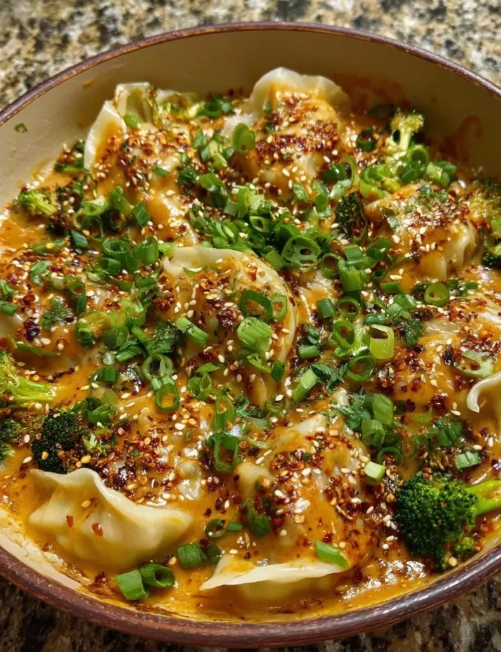 Oven-baked dumplings drizzled with creamy peanut sauce on a plate.