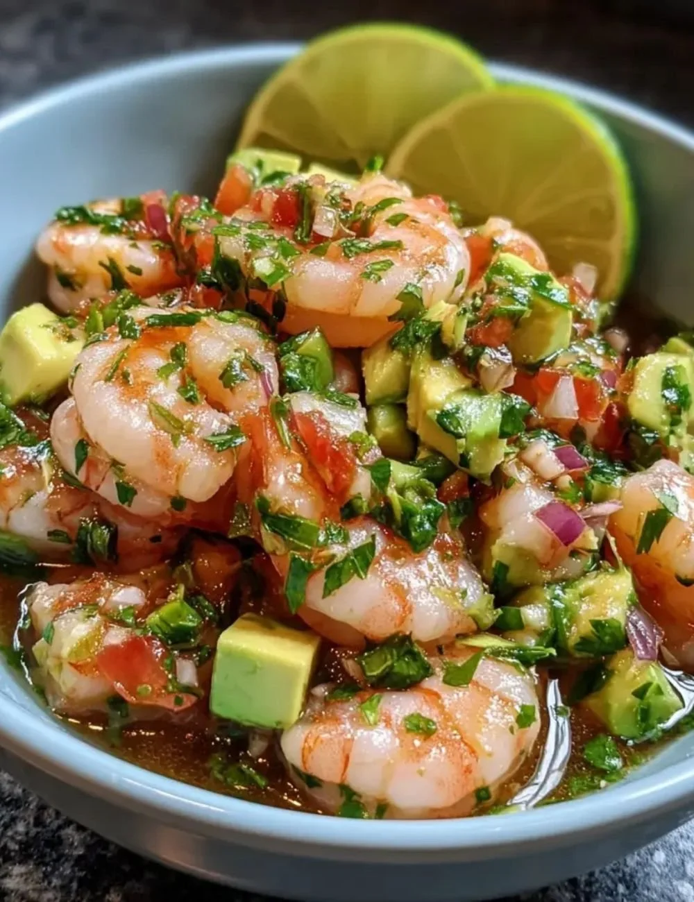 Chilli Lime Shrimp Ceviche served in a bowl with lime wedges and fresh herbs