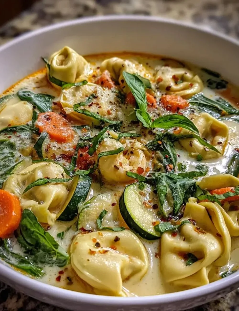 Creamy vegetable tortellini soup with fresh vegetables and pasta served in a bowl