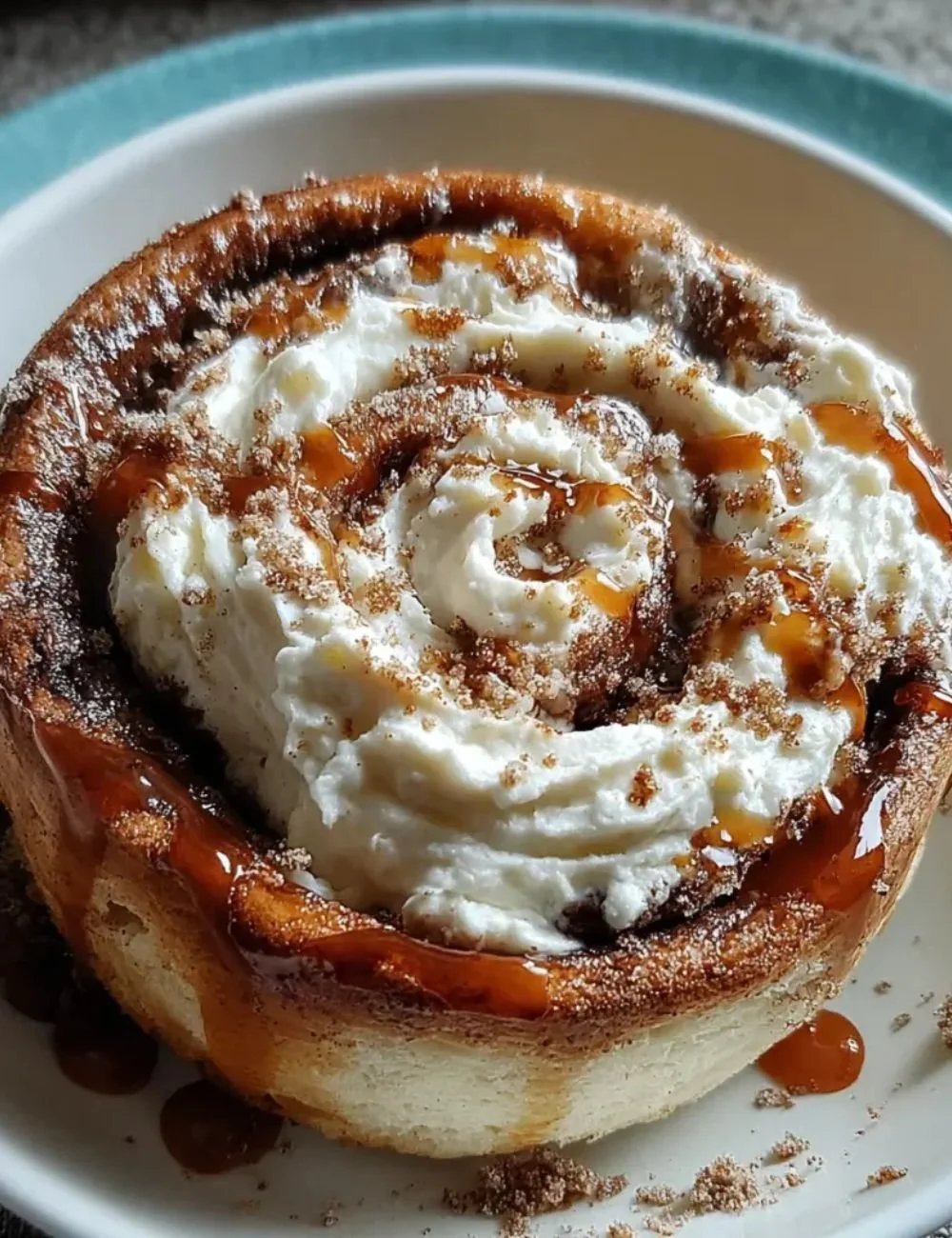 High-protein cinnamon roll mug cake topped with cream and cinnamon