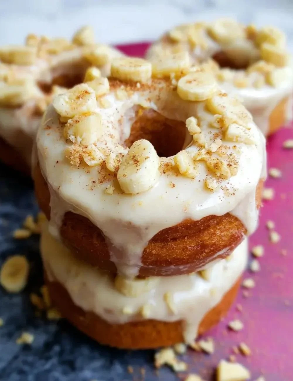 Delicious banana donuts with cinnamon cream cheese frosting on a plate