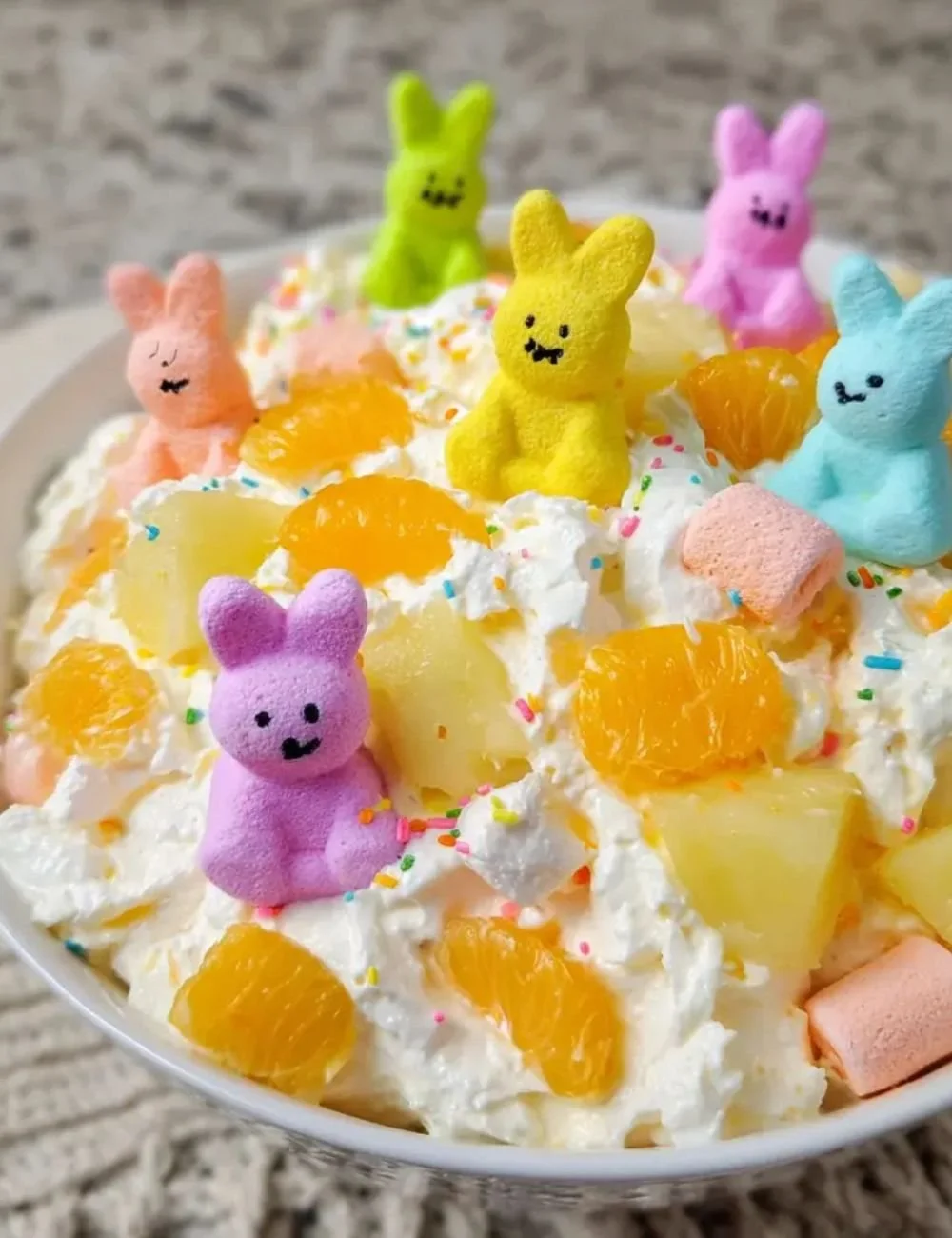 Colorful Easter Fruit Fluff Salad with mixed fruits and fluffy cream topping.