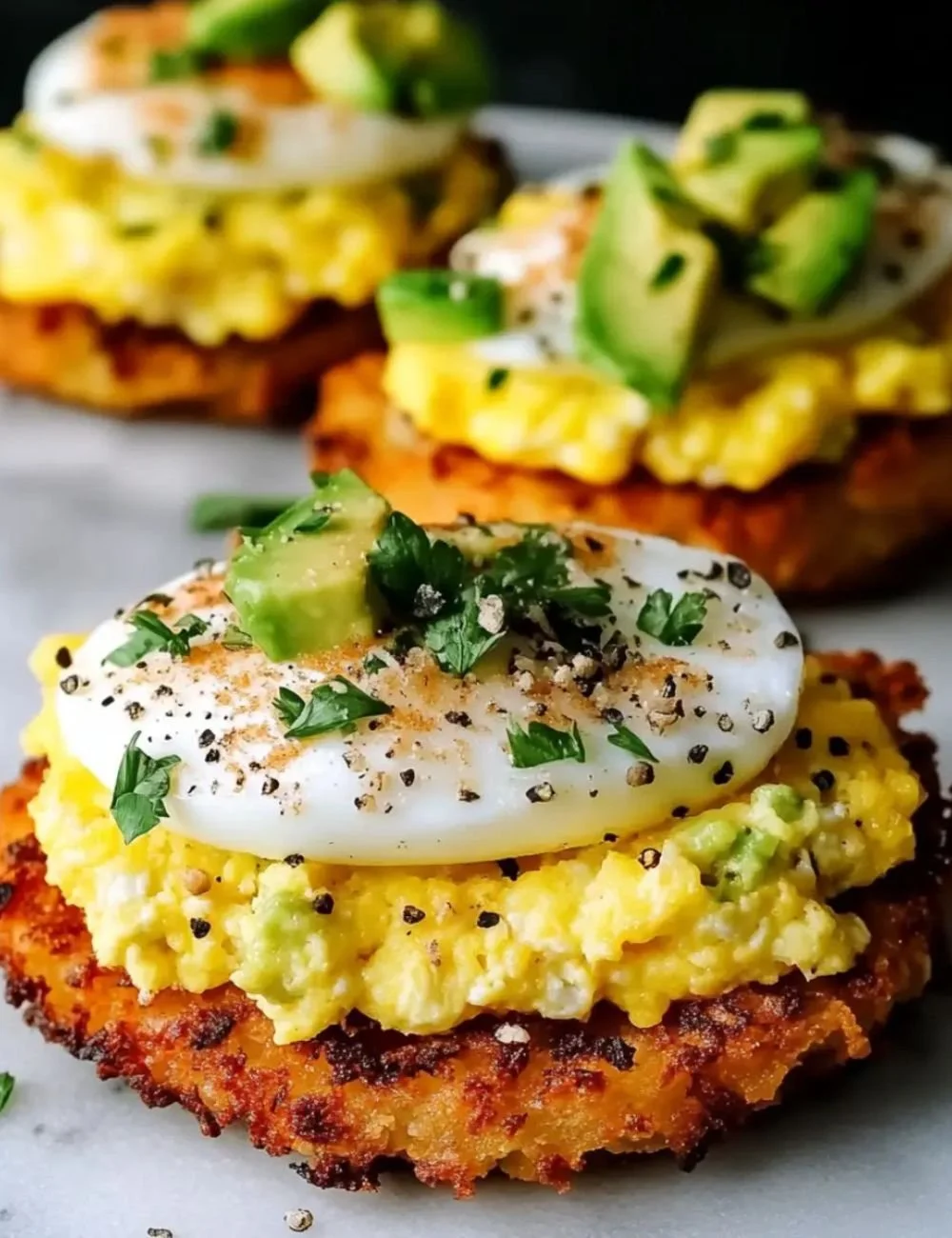 Plate of crispy hash browns served with creamy scrambled eggs.