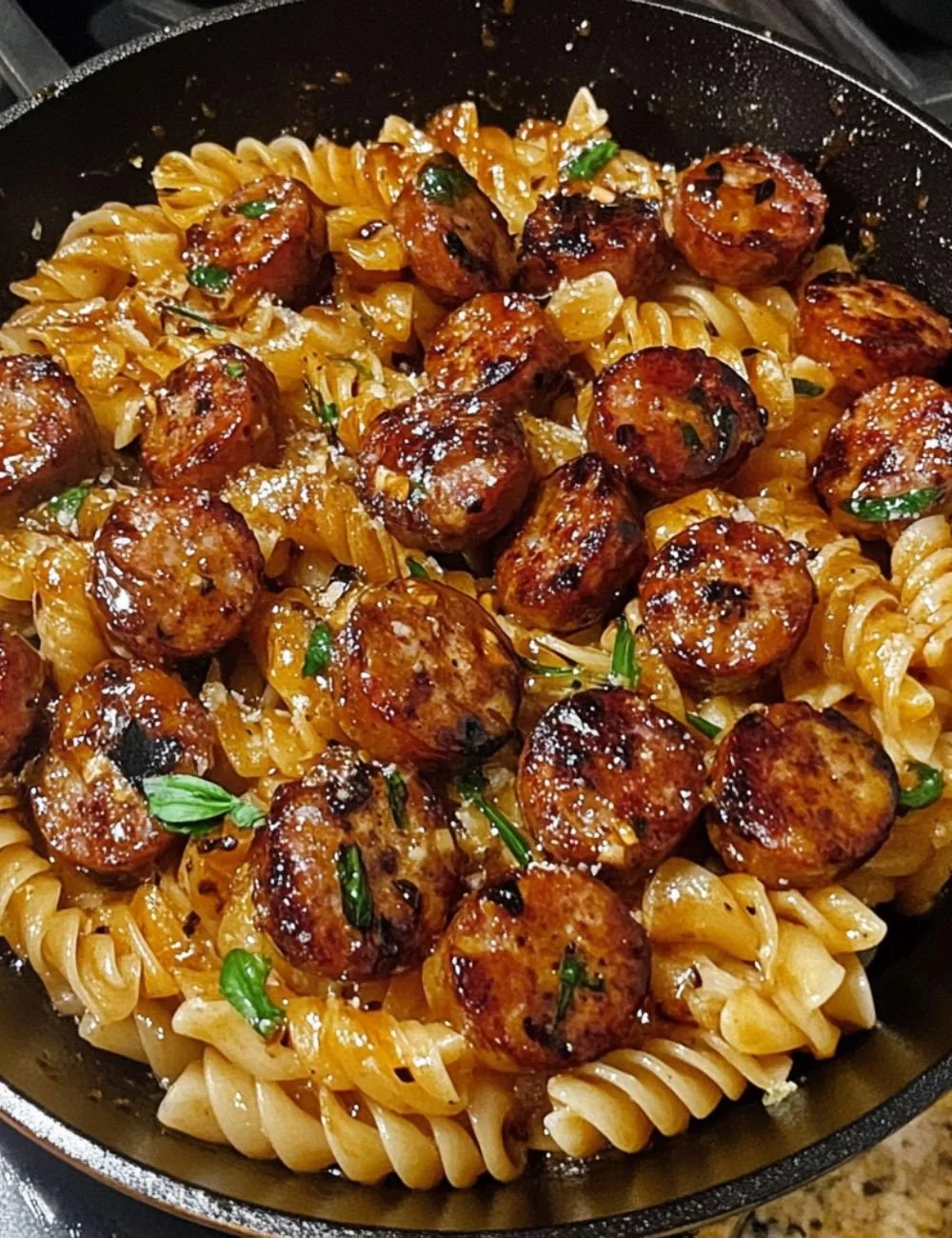 Sticky honey garlic sausage pasta skillet ready to serve