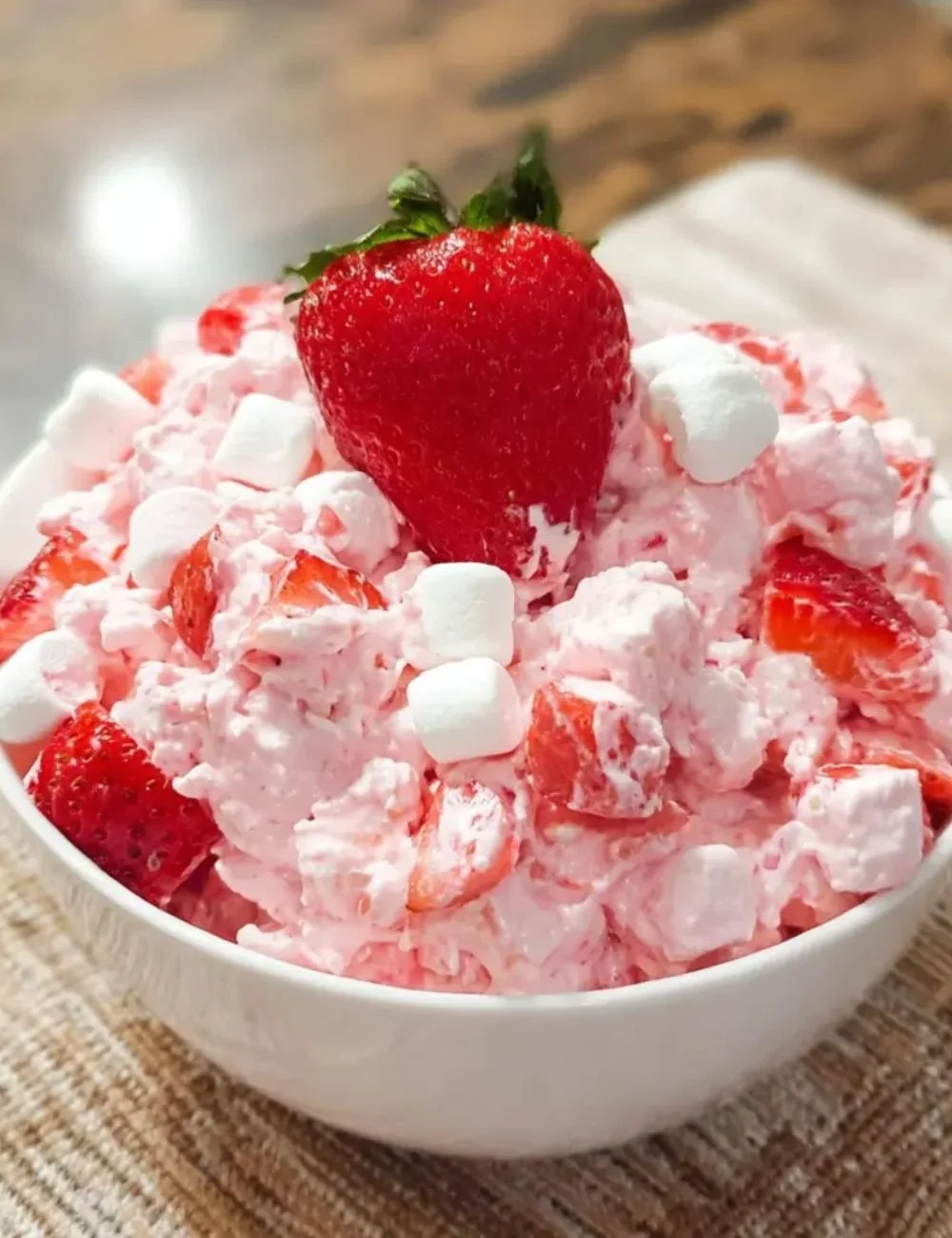 Bowl of creamy Strawberry Fluff Salad garnished with fresh strawberries