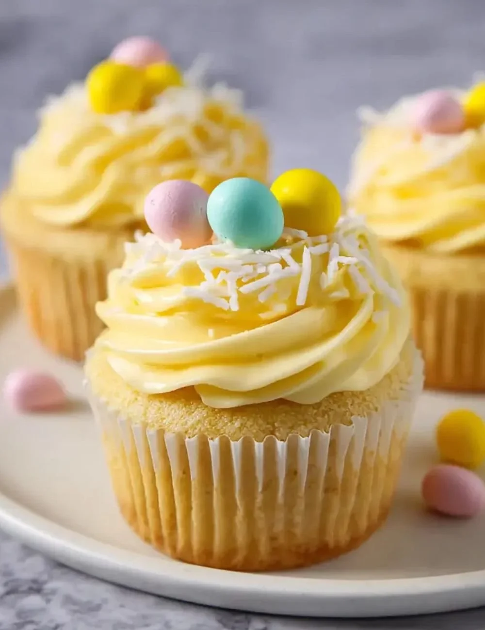 Lemon curd Easter cupcakes topped with frosting and zest
