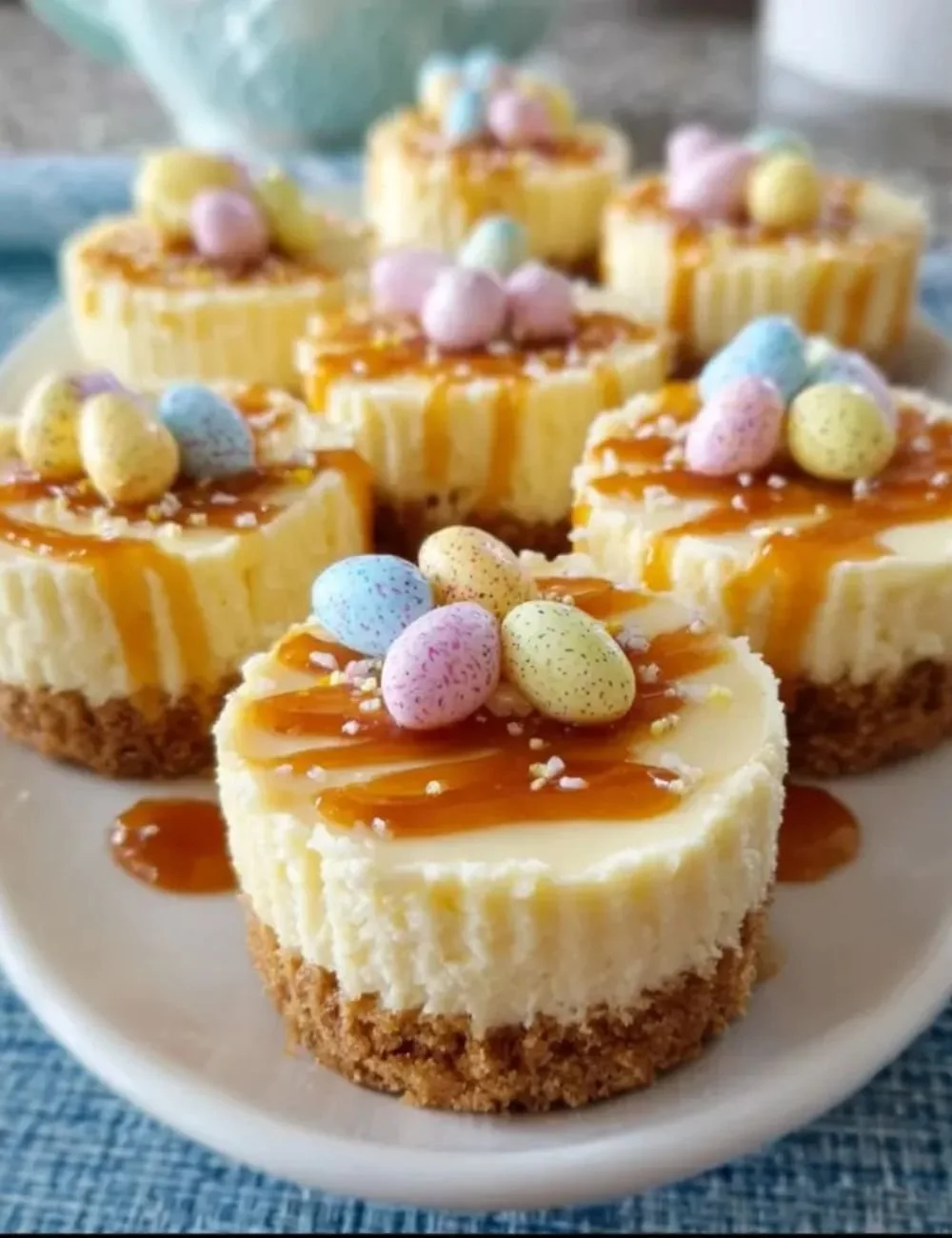Mini Easter cheesecakes topped with colorful chocolate eggs for a festive dessert.